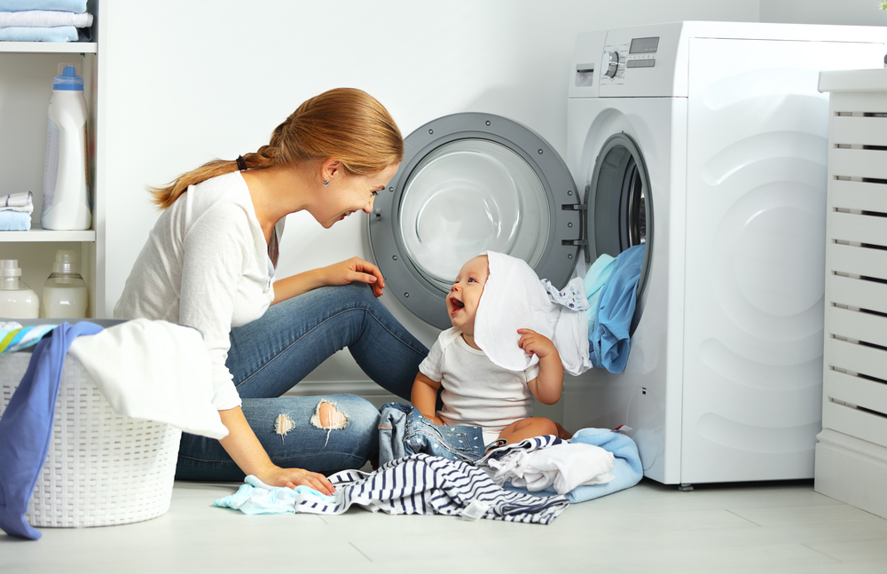 how to clean a stinky washing machine - mom and baby near washing machine